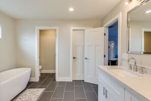 Bathtub, hair dryer, towels, toilet paper