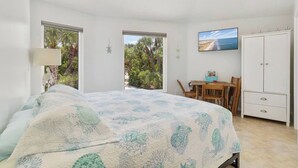 A bedroom with a bed, a desk, and a wardrobe. There are windows and a TV mounted on the wall. - Boaters Paradise W Dock Access - .4 Mile to Beach (Englewood)