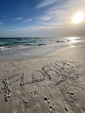 A beach with footprints and the word 'LOVE' written in the sand. - Cozy Two-Bed Retreat! (Sarasota)