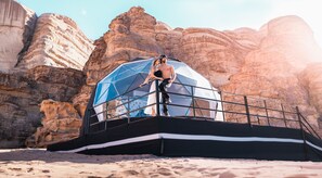 A geodesic dome structure with a metal railing, set against a rocky canyon backdrop. - Aladdin Camp (Wadi Rum)