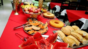 A buffet table with various fruits, a donut, and bread rolls. - Amazonia Palace Hotel (Maraba)