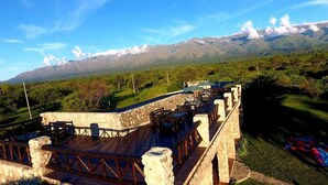 A stone bridge with a wooden deck, overlooking a lush landscape with mountains in the background. - La Maina Cabañas (San Javier)