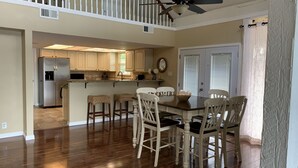 A spacious kitchen with a central island, wooden chairs, and a ceiling fan. - Waterfront Home! Relax & Enjoy the Serenity of Lake Palestine.  
 (Chandler)