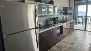 Una cocina moderna con electrodomésticos de acero inoxidable, horno empotrado y cafetera.