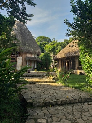 A traditional village with thatched-roof houses, stone pathways, and lush greenery. - Eco-Hotel Sak Nok (Ocosingo)