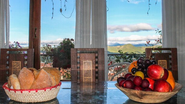 A table with a basket of bread and a bowl of fruit. - Cabaña - Bar- Restaurante El Mirador (Vallegrande)