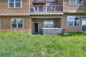 A two-story building with a balcony, a garage door, and a grassy yard. - Winter Park Chalet w/ Hot Tub + Free Shuttle! (Fraser)