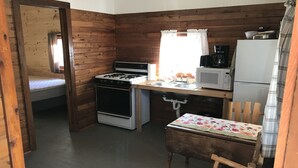 A compact kitchen with a stove, microwave, and refrigerator. - Cabin #2 Near Beautiful Brevort Lake (Moran)