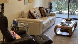 A living room with a sofa, two armchairs, a coffee table, and a glass table with a lamp. - PSP Dream Stay -  Large 2 bdm 2 bth condo- pickleball, tennis, all amenities  (Palm Springs)