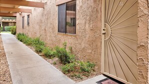 A building with a textured facade, a gated entrance, and a concrete pathway. - PSP Dream Stay -  Large 2 bdm 2 bth condo- pickleball, tennis, all amenities  (Palm Springs)