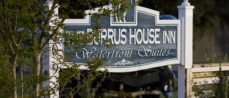 A sign for the ZURUS HOUSE INN Waterfront Suites.