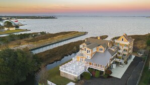 A large wooden house with multiple balconies, a dock, and a view of the water. - The Burrus House Inn Waterfront Suites (Manteo)