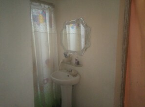 Bathroom features a pedestal sink, mirror, and frosted glass window.