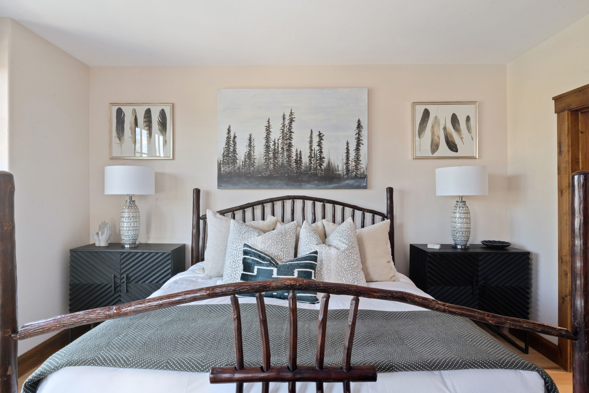 Une chambre à coucher avec un lit, deux tables de chevet et un tableau accroché au mur.