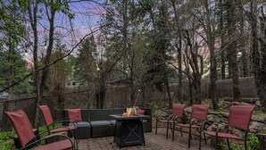 Un patio con una chimenea, asientos y un muro de piedra.