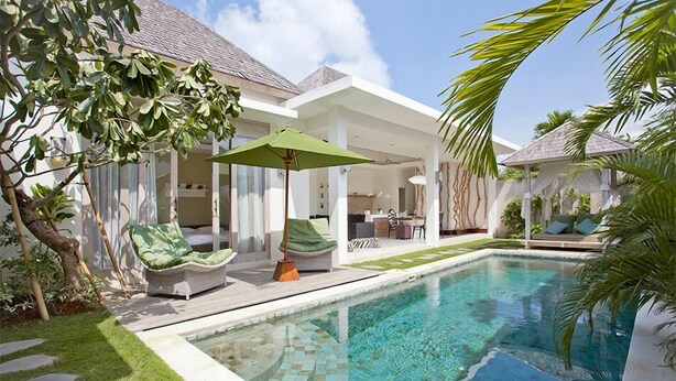 A modern pool area with a clear pool, lounge chairs, and a covered seating area. - Le Chloe Villas (Seminyak)