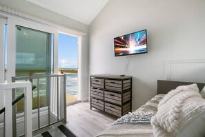 En moderne stue med et stort vindue, et fladskærms-tv og et træskab.