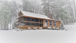 A wooden cabin with a snow-covered roof, surrounded by trees. - Smoky Mountain Loft - UNBELIEVABLE MOUNTAIN VIEWS, Great Location, Free Tickets! (Pigeon Forge)