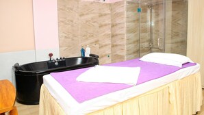 A room with a bed, a bathtub, and a shower area. - Nam Son Hotel (Hanoi)