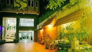A hotel entrance with a staircase leading inside, a tiled floor, and a sign above the entrance. - Nam Son Hotel (Hanoi)