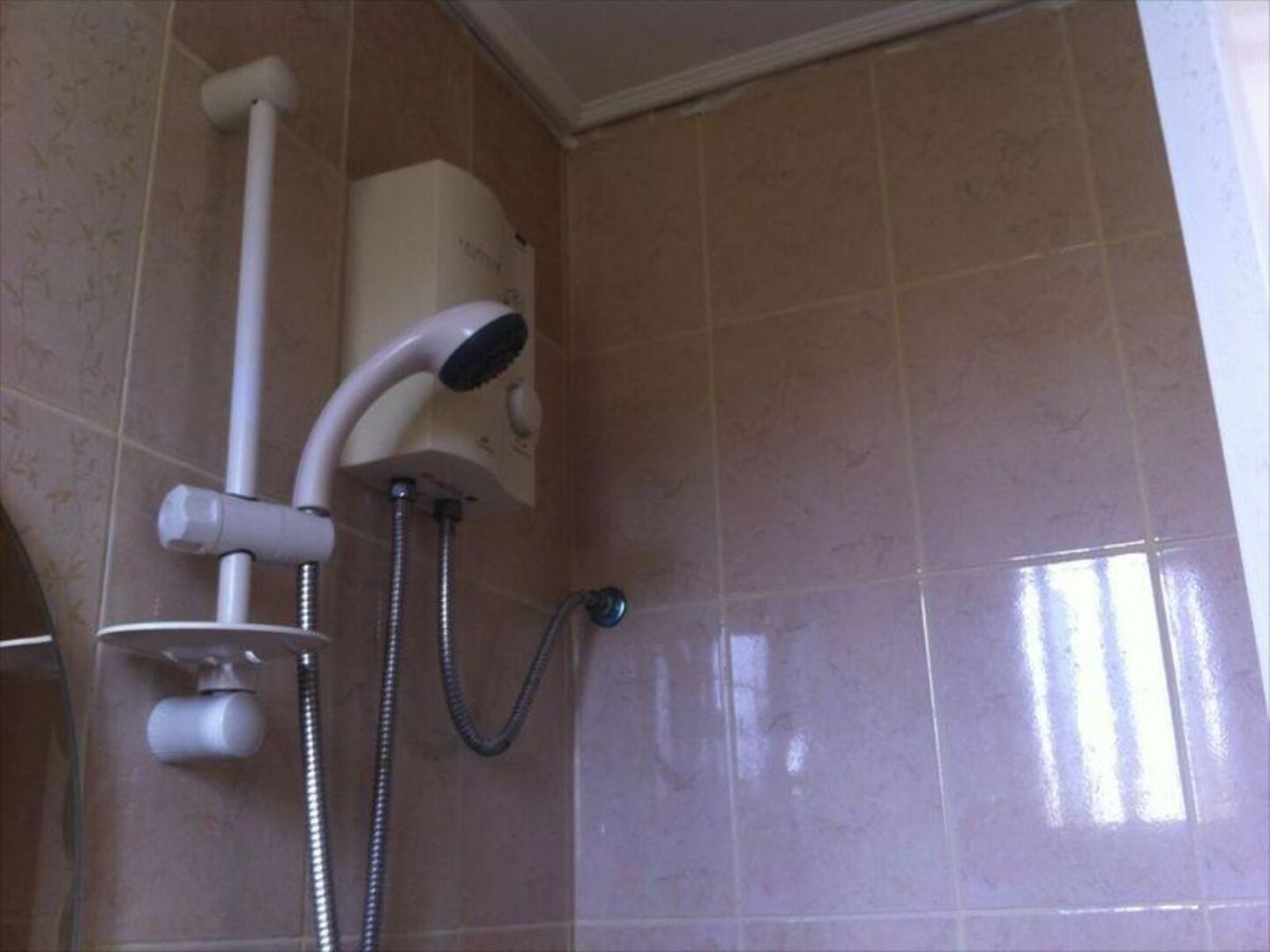 A shower with a handheld showerhead and a fixed wall-mounted showerhead, connected by a flexible hose.