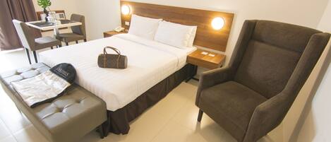 Une chambre d’hôtel avec un lit, une chaise, un bureau et une table.