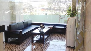 A modern living room with a sofa, coffee table, and a refrigerator. - Thiên Các 2 (Quy Nhon)