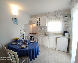 Een koelkast, een oven, een kookplaat, een koffiezetapparaat/waterkoker