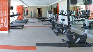 A gym with multiple treadmills, stationary bikes, and weight machines. - 8 Newtown Boulevard by SIET (Lapu-Lapu)