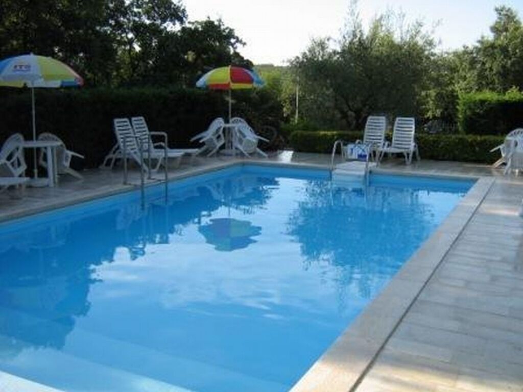Una piscina amb gandules i ombrelles.