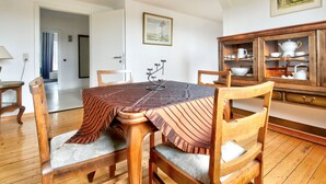 A dining area with a round table, wooden chairs, and a cabinet with glass doors.