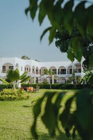 Un edificio blanco con múltiples arcos y una zona de estar al aire libre techada.