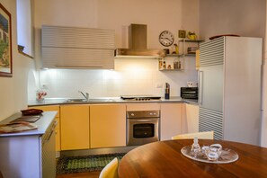 Una cocina compacta con estufa, horno y refrigerador.