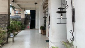 A corridor with hanging pendant lights, a staircase, and potted plants. - Chiasti Capsule Hostel - Adults Only (Cebu City)