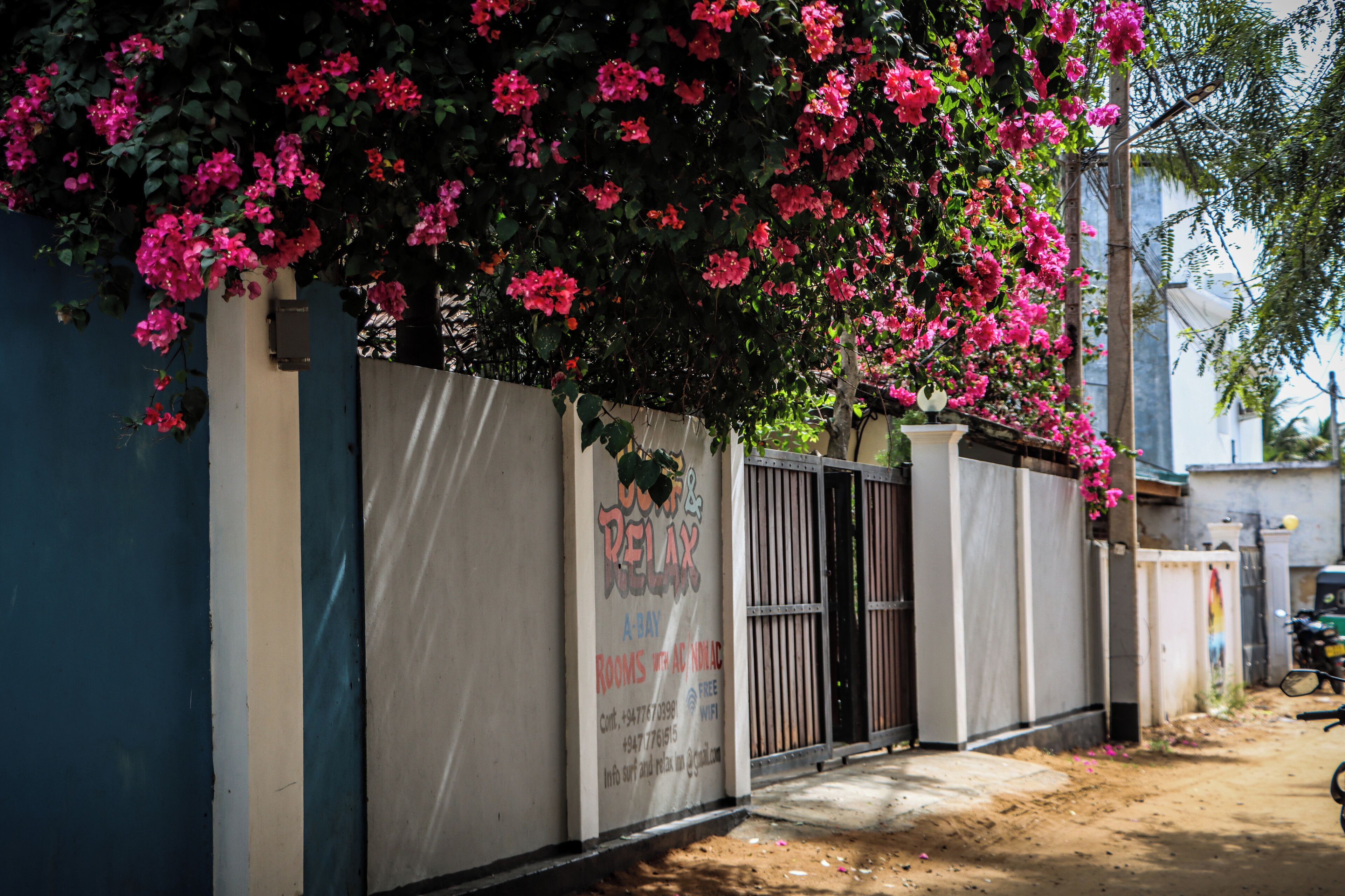 A gated property with a sign advertising rooms for rent.