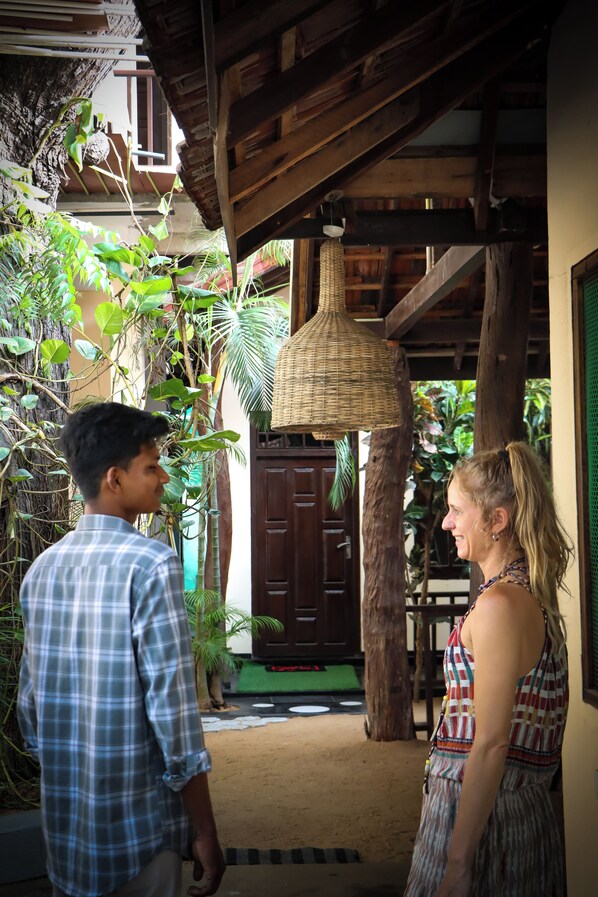 A wooden structure with a woven ceiling light, a brown door, and a green wall. - Surf & Relax Inn Arugambay (Arugam Bay)
