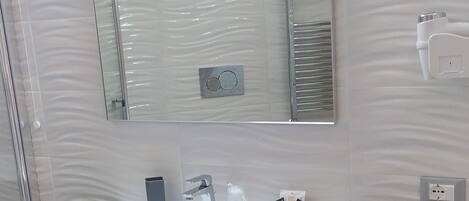 A bathroom with a white sink, a mirror, and a towel rack.