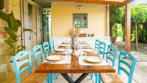 A dining table set for six with blue chairs, a wooden table, and a white wall in the background. - Beautiful private villa for 8 guests with WIFI, A/C, pool, TV, patio and panoramic view (Ostra)