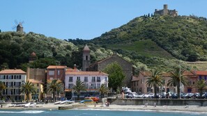 A coastal town with a historic windmill, a church, and a castle on a hill. - Large cottage in renovated Templar mas - panoramic view (Occitanie)
