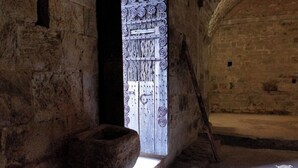 A stone-walled room with a wooden door featuring intricate carvings. - Large cottage in renovated Templar mas - panoramic view (Occitanie)