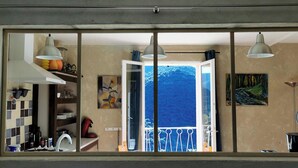 A kitchen with a view of a mountain through a window. - Small nest for 2 with 180 ° view on wooded hills in a cozy cottage (Occitanie,)