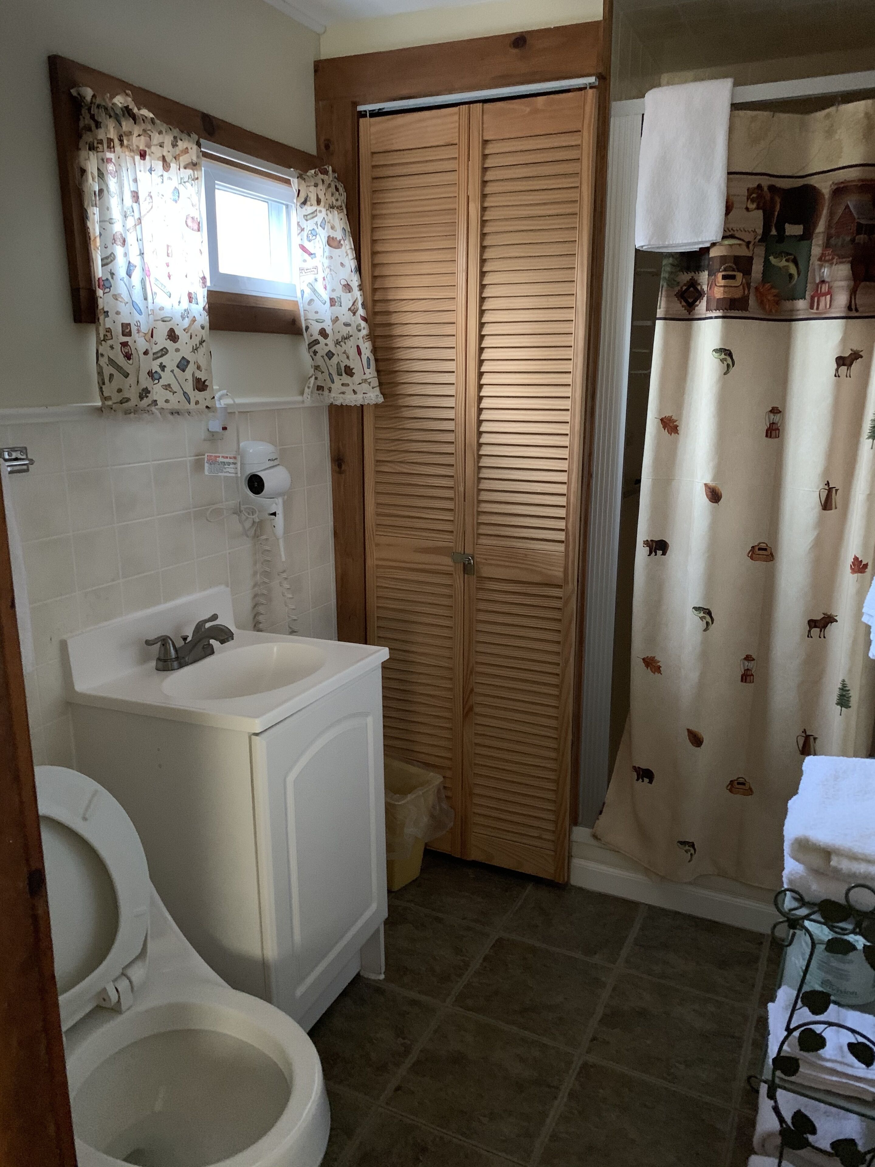 Ein Badezimmer mit Toilette, Waschbecken und Holztür.