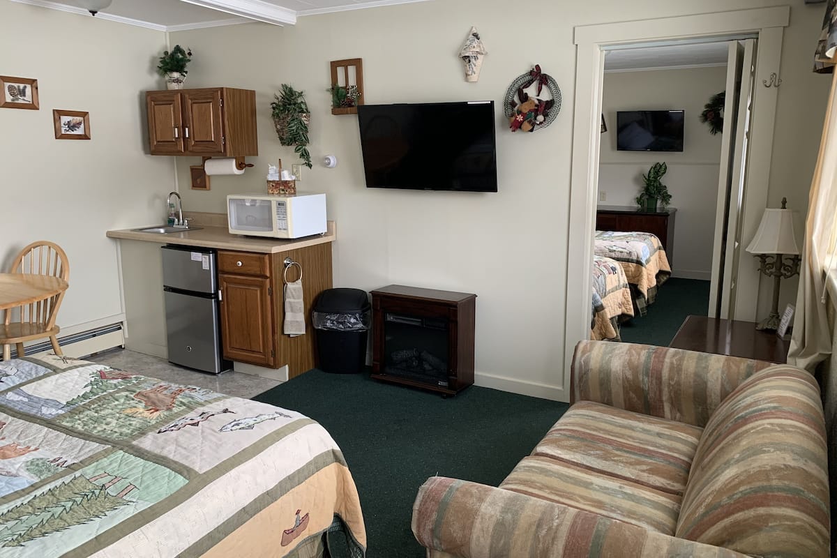 A compact living space with a kitchenette, a dining area, and a bedroom.