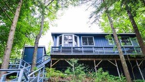 Eine Holzhütte mit Balkon, umgeben von Bäumen.