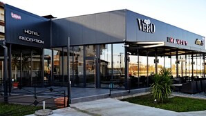 A modern building with a reception area labeled "HOTEL RECEPTION" and a cafe named "caffe VERO". - Hotel Moment (Velika Plana)