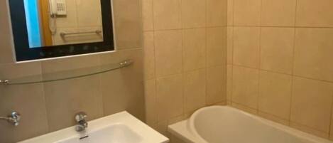 A bathroom with a white sink, a mirror, and a bathtub.