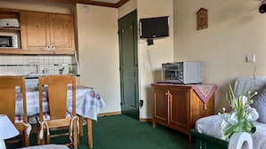 A compact kitchen with wooden cabinets, a microwave, a toaster, and a television mounted on the wall. - APARTMENT AT THE FOOT OF PISTE 4/5 PEOPLE (LA PLAGNE-TARANTAISE)