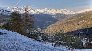A snowy mountain landscape with a ski lift and a clear view of snow-covered peaks. - APARTMENT AT THE FOOT OF PISTE 4/5 PEOPLE (LA PLAGNE-TARANTAISE)
