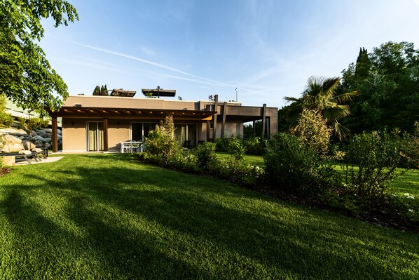 Una casa moderna con césped bien cuidado y muebles de patio.
