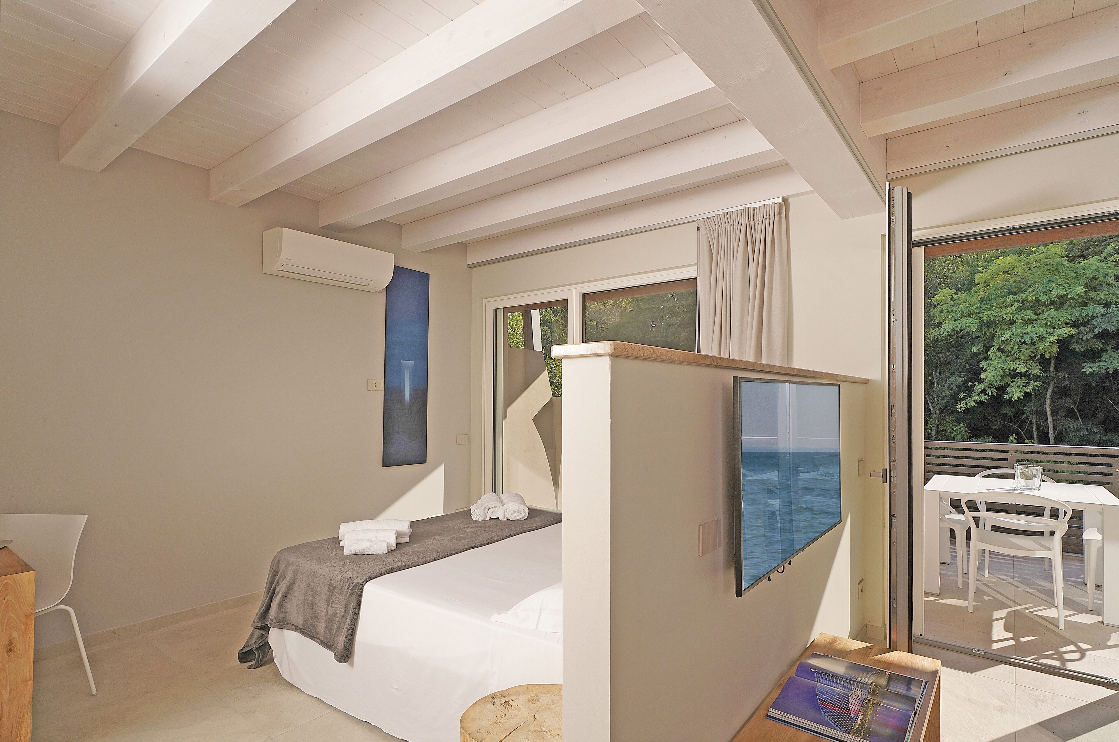 Un dormitorio con cama, escritorio y vistas al exterior.